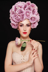 Young beautiful woman in fancy vintage style wig of roses and corset