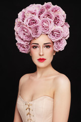 Young beautiful girl in corset and vintage style wig of roses 