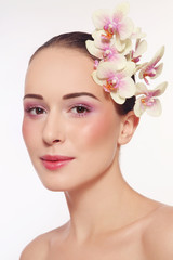 Fototapeta premium Portrait of young beautiful happy healthy woman with fresh make-up and white orchid