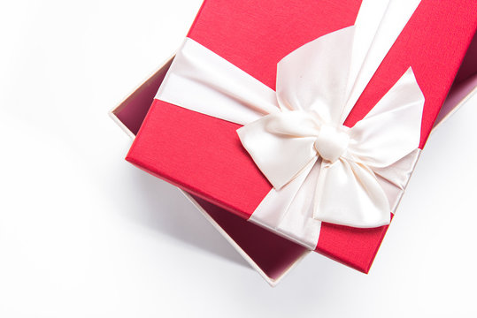 Red gift box with white ribbon isolated on white background. 