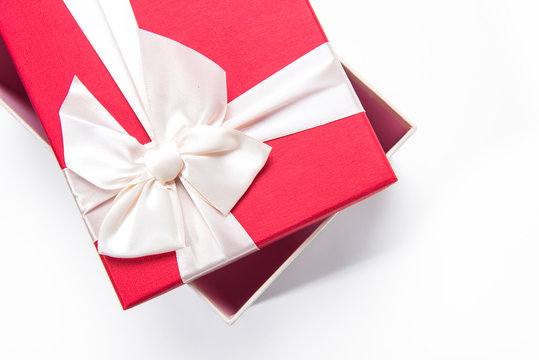 Red gift box with white ribbon isolated on white background. 