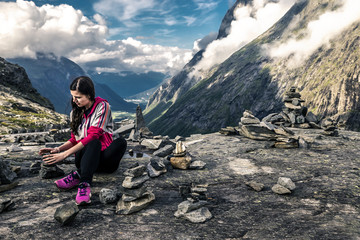 Fototapeta premium Young woman collecting stones in Norway
