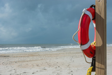 Lifeguard station on the beach.  Life preserver on a pole.  Safety.  Emergency flotation device.  