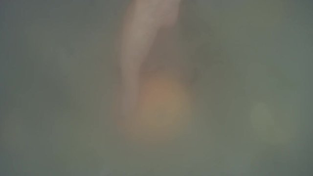 4k Shot of Cold Ice Cubes and hand Holding Orange from Fog
