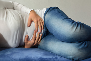 Attraktive junge Frau mit Bauchschmerzen