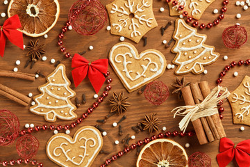 Christmas gingerbread on brown, wooden background with various decoration and spices