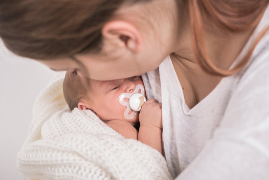 Mutter kuschelt mit Neugeborenem