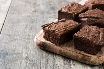 Chocolate brownie portions on wooden background
