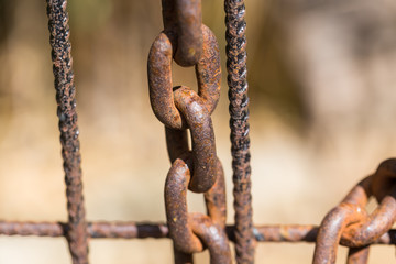 Rusty chain on an old metal fence