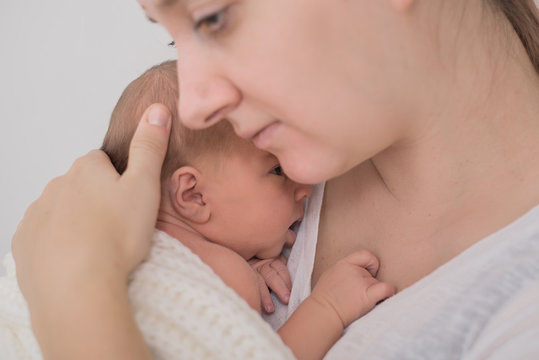 Mutter kuschelt mit Neugeborenem
