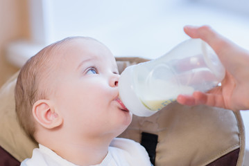 Mother feeds baby from a bottle of milk