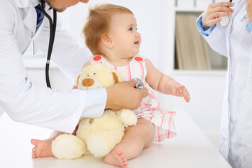 Happy cute baby  at health exam at doctor's office. Medicine and health care concept