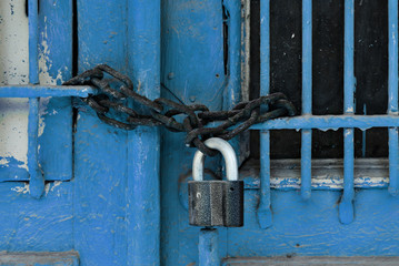 Padlock with a chain on blue door