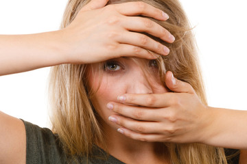 Ashamed embarrassed blonde woman with hands on face