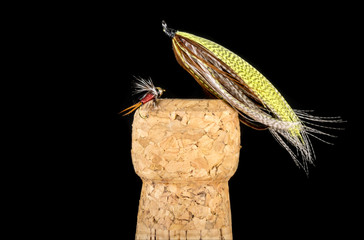 Colorful Hand Tied Fishing Flies Displayed on Champagne Cork Isolated on Black