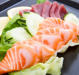 tuna and salmon sashimi on black dish