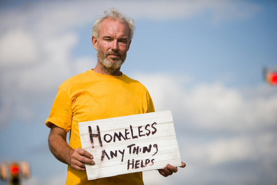 Homeless man with a sign asking for help.