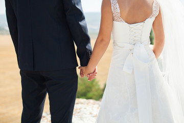 Bride and groom walking together holding their hands