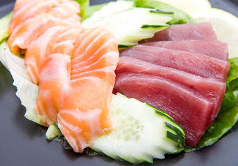 tuna and salmon sashimi on black dish