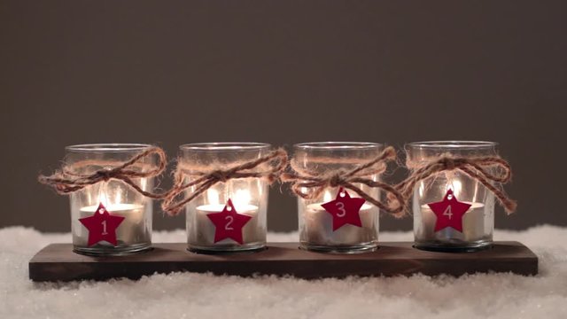Four Advent candles in the snow, fourth Advent