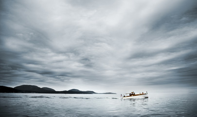 Boat on a blue foggy ocean. Maine