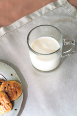 cookies and milk are on a white tablecloth