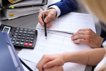 Bookkeeper or financial inspector and secretary making report, calculating or checking balance. Internal Revenue Service inspector checking financial document. Audit concept.