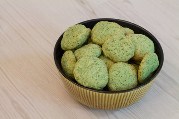 Mint cookies in bowl on wood