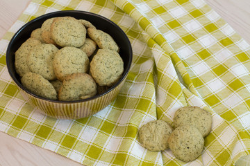 Lemon cookies in bowl on yellow checkered napkin. 