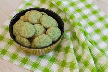 Mint cookies in bowl on green checkered napkin. 