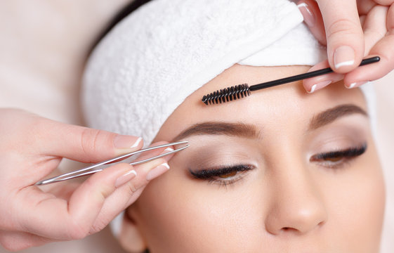 Beautiful young woman gets eyebrow correction procedure