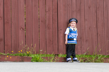 Baby caucasian girl toddler dressing up playing in police unifor
