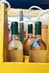Obraz premium Bottles of white wine in a yellow bottle rack