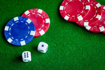 poker chips and dice on green background top view
