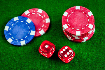 poker chips and dice on green background top view