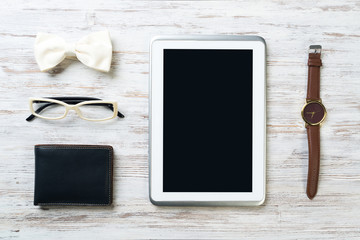 Gentleman kit of tablet watch glasses bow tie and notebook on wooden table
