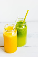 Fresh detox juices in glass bottles on white background