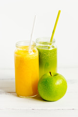 Fresh detox juices in glass bottles on white background