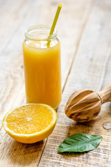 freshly squeezed orange juice in glass bottle on wooden background