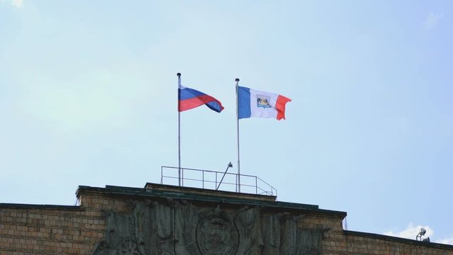 Administrative building of Velikiy Novgorod with waving flags of Russia and Velikiy Novgorod