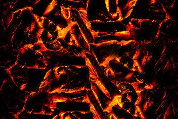 Smoldering ashes of a bonfire. incandescent orange and red embers texture. Concept from alfaphoto