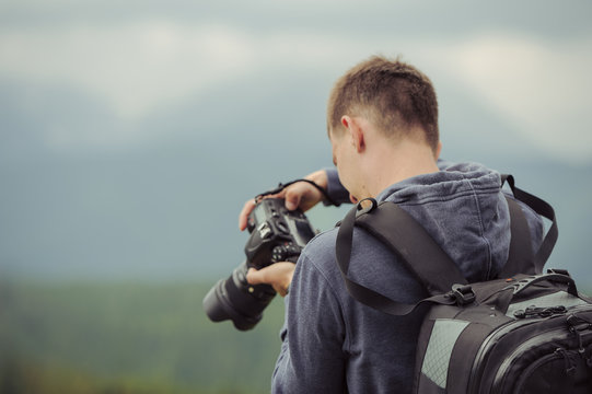 man photographer takes pictures in mountain