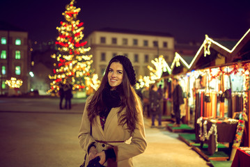 Pretty woman in christmas market during cold evening