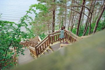 girl sitting on the wooden stairs in park and smiling