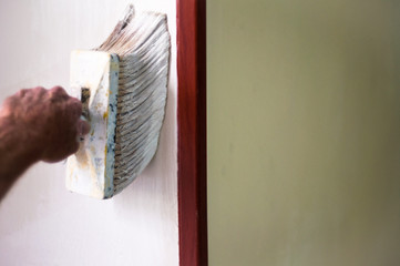 Painter painting the walls with fully loaded large brush