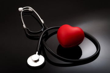 Stethoscope and heart for blood pressure check up on black background