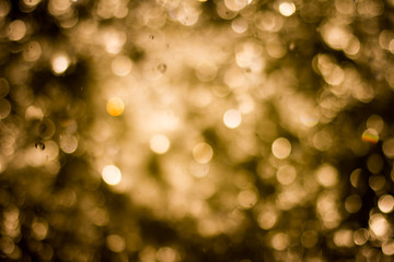 golden bokeh on a black background, abstract dark backdrop with