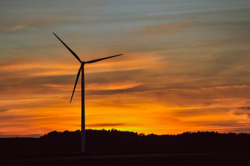 Obraz premium Silhouette of wind turbine on sunset