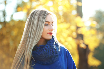 Naklejka premium Beautiful young woman in autumn park on sunny day