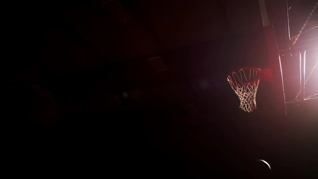 Two basketball players jump up and slam dunk, slow motion, view from below